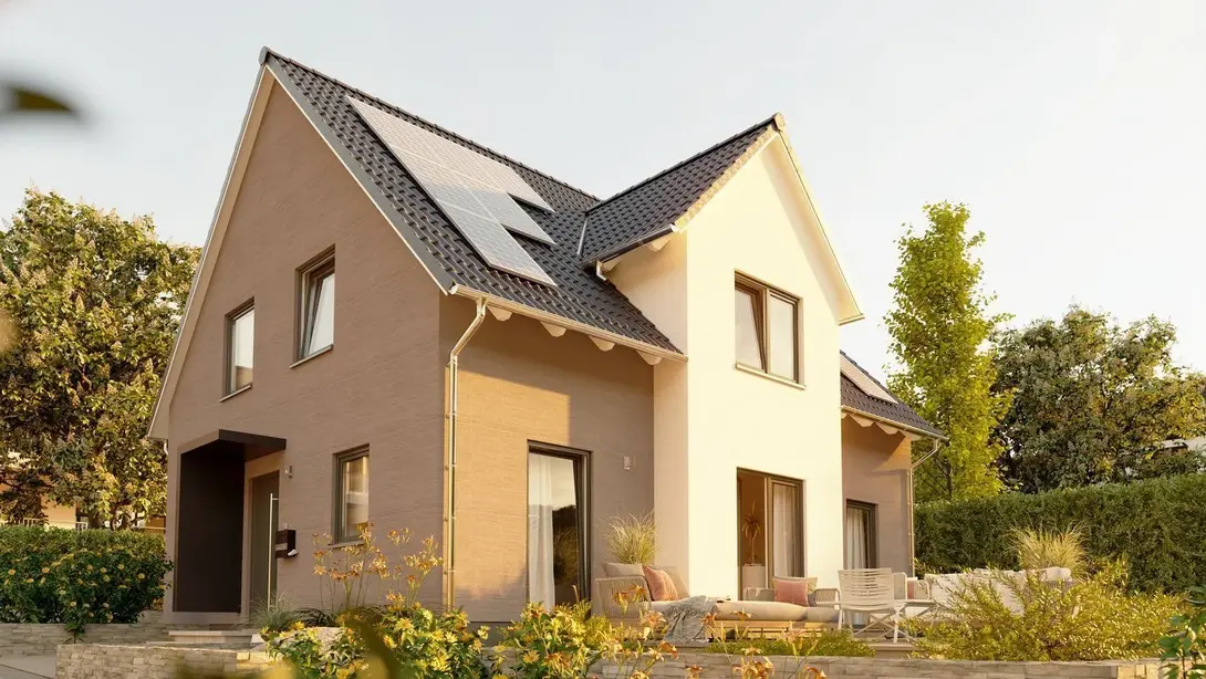 Energieeffizientes Einfamilienhaus in Rheine Modernes Einfamilienhaus mit Terrasse und Solarmodulen auf dem Satteldach in einem gepflegten Garten bei Abendlicht.