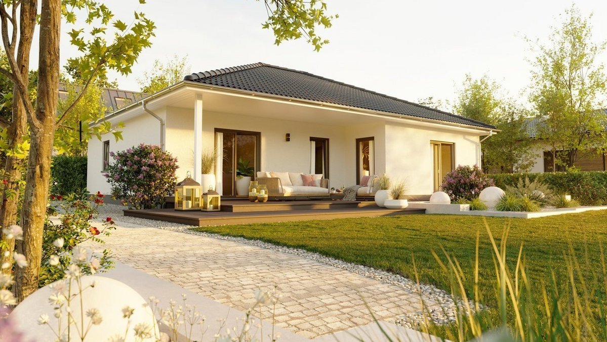 Moderner Bungalow mit Walmdach, Terrasse, Gartenweg und gepflegter Außenanlage bei warmem Abendlicht