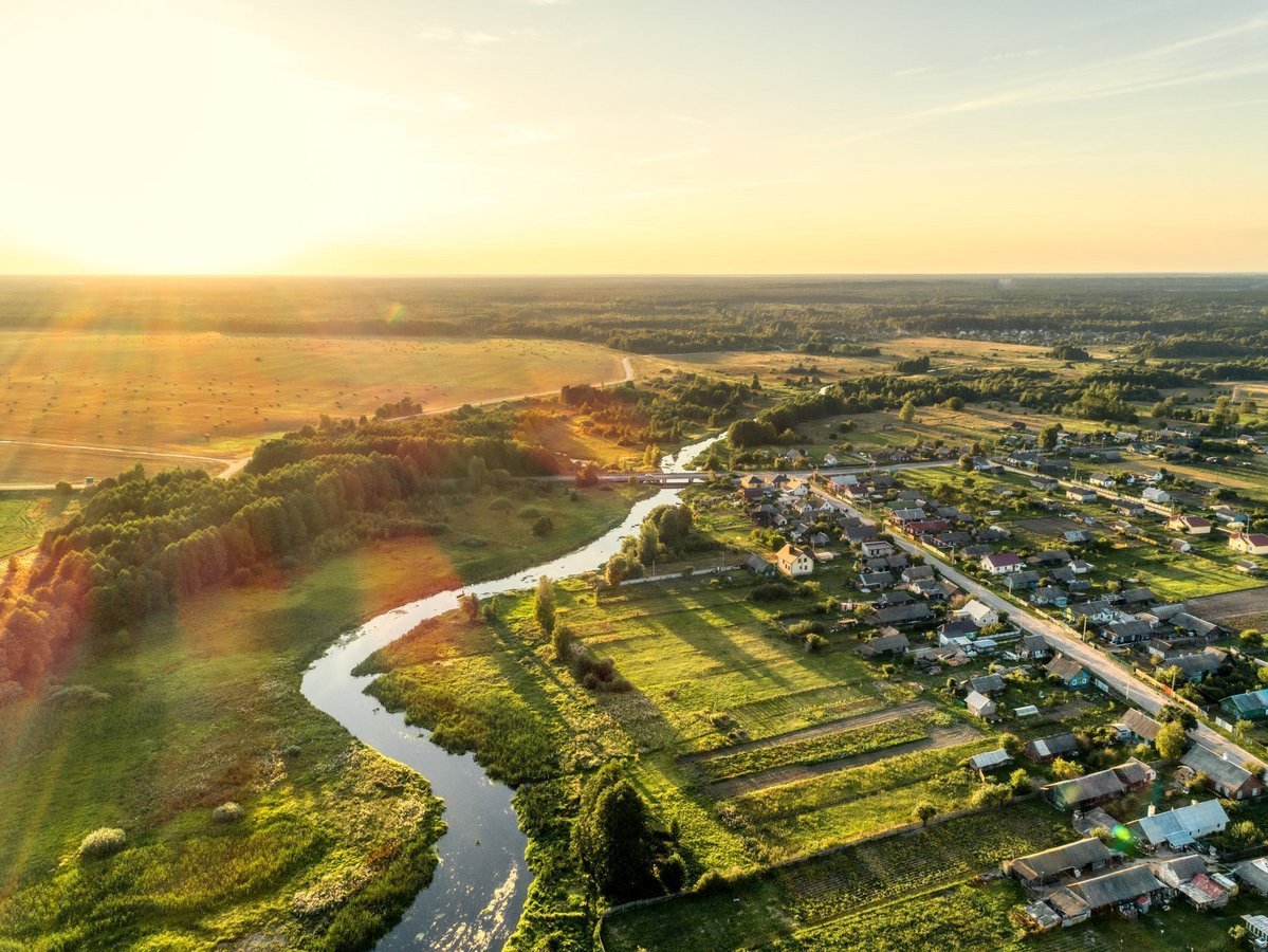 Naturnah wohnen im Baugebiet Silberweg West Luftaufnahme einer grünen Flusslandschaft mit Wohngebiet als Symbolbild für naturnahes Wohnen in Emsdetten