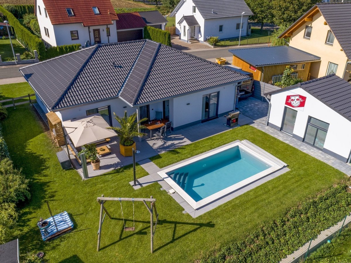 Bungalow mit Garten im Baugebiet Vennweg Süd Luftaufnahme eines modernen Bungalows mit großem Garten und Pool als Beispiel für Hausbau im Baugebiet Vennweg Süd in Emsdetten