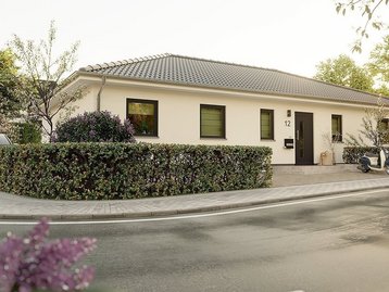 Moderner Bungalow mit heller Fassade, flachem Walmdach, gepflegtem Vorgarten und überdachtem Eingangsbereich