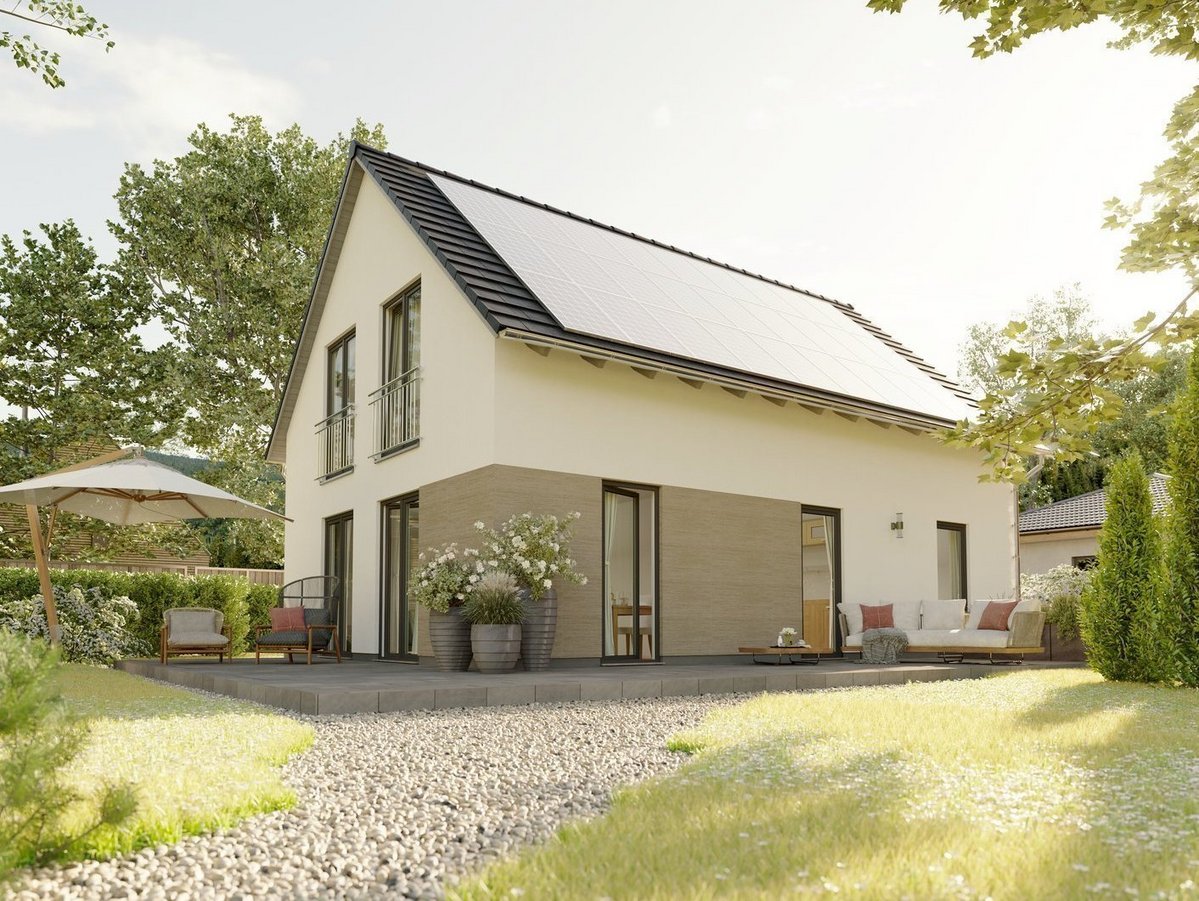 Modernes Einfamilienhaus mit großer Photovoltaikanlage auf dem Satteldach und Terrasse im Garten.