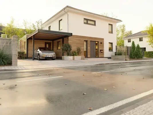 Modernes Einfamilienhaus mit Carport von Thielker Massivhaus Modernes Massivhaus mit Holzfassade und Carport an einer ruhigen Straße – Einfamilienhaus von Thielker Massivhaus.